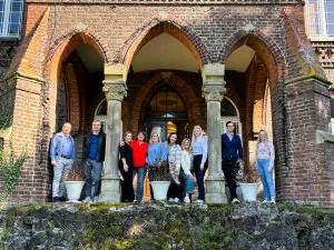 Teilnehmer der „Führungswerkstatt“ stehen unter den Steinbögen vor dem Eingang der schönen Marienburg Monheim am Rhein